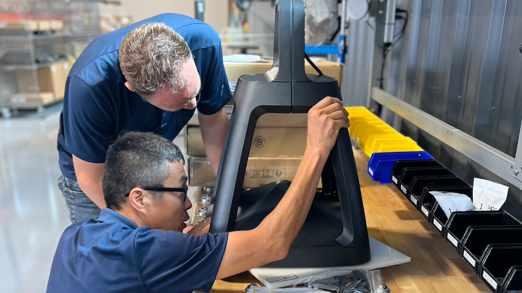 Solar lighting design process Fonroche Lighting America technicians assembling and inspecting a solar lighting fixture in manufacturing facility