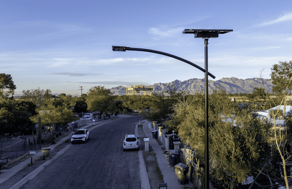 essential-solar-street-light Fonroche ESSENTIAL solar street light installed along a residential roadway with mountain views, featuring autonomous LED lighting for streets, parking lots, trails, and public spaces.