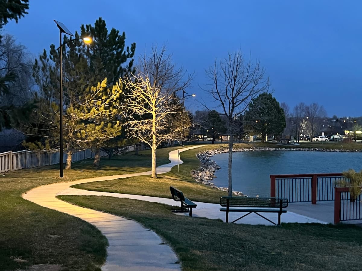 solar lighting for public parks Solar pathway lighting illuminating a lakeside park trail for safe nighttime pedestrian access.