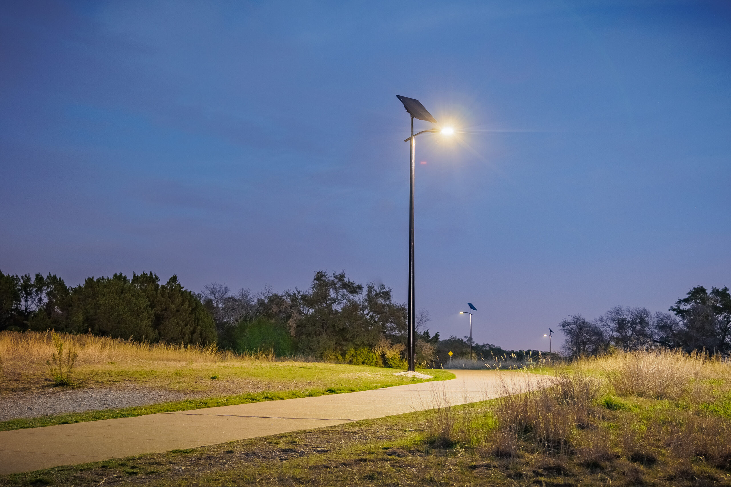 Solar pathway lighting illuminating a park trail at night