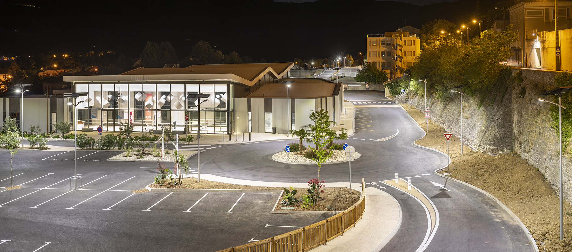 Commercial-grade solar lights installed in a large parking lot for energy efficiency. Solar lighting illuminating a large commercial parking area and roadway at night