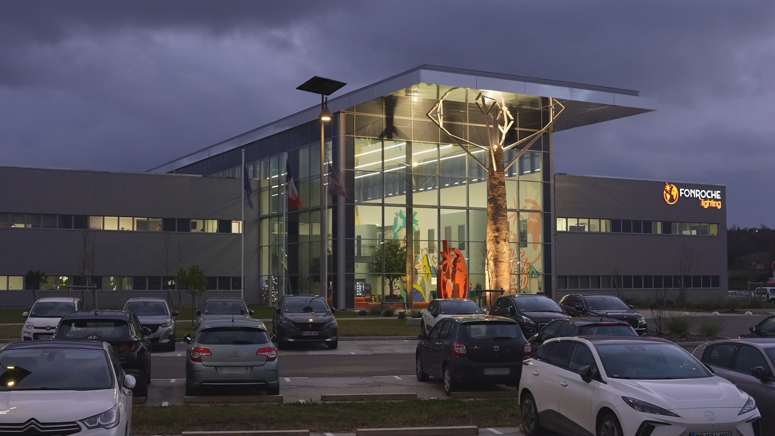 fonroche-lighting-france-headquarters Commercial solar lighting installed outside a modern office and parking facility at dusk