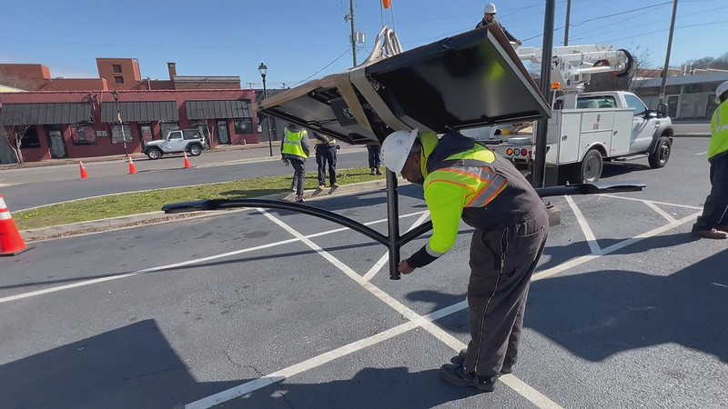 Municipal worker inspecting a Fonroche solar streetlight before installation as part of a cost-efficient, off-grid lighting upgrade