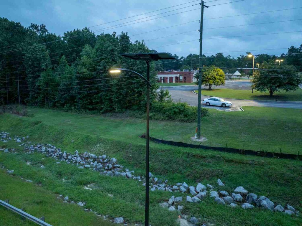Solar-powered street light pole in Georgia providing sustainable lighting near a community roadway.