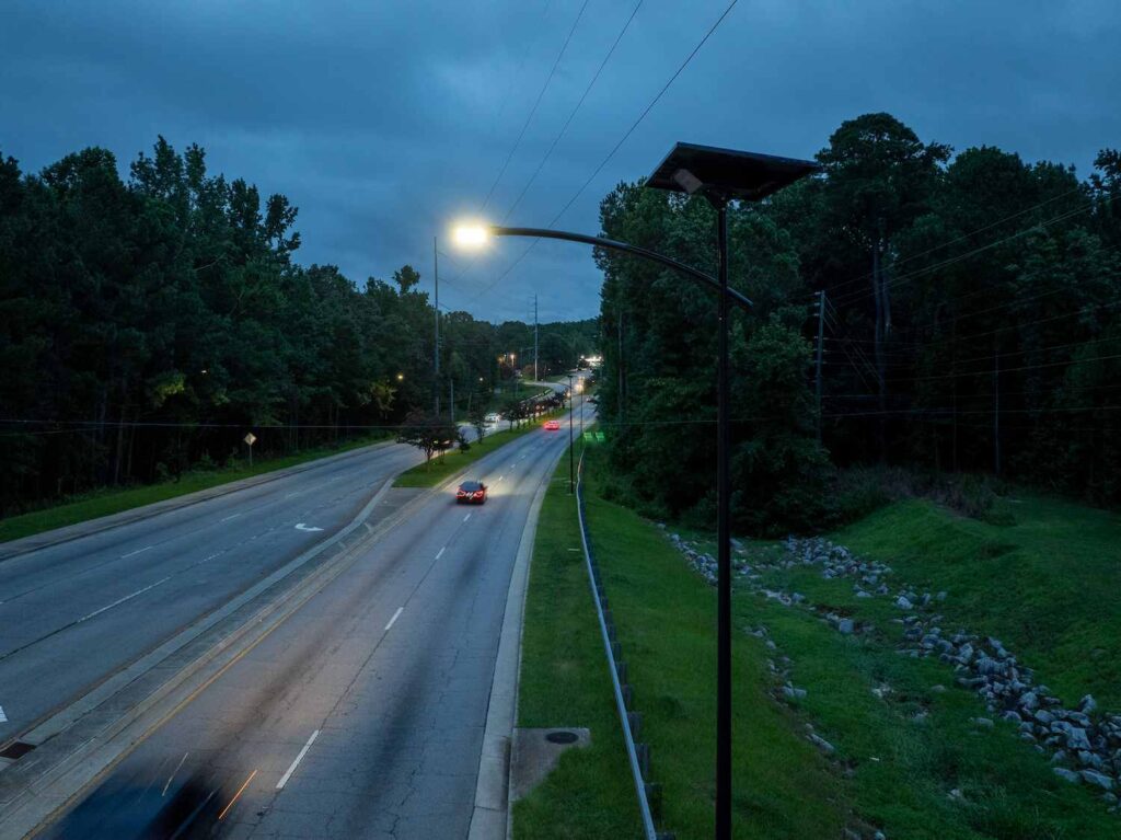 Off-grid solar streetlight illuminating a busy Georgia roadway at dusk, ensuring safe and reliable lighting without grid power.