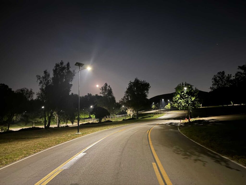 Solar streetlights illuminating a winding community road at night in California