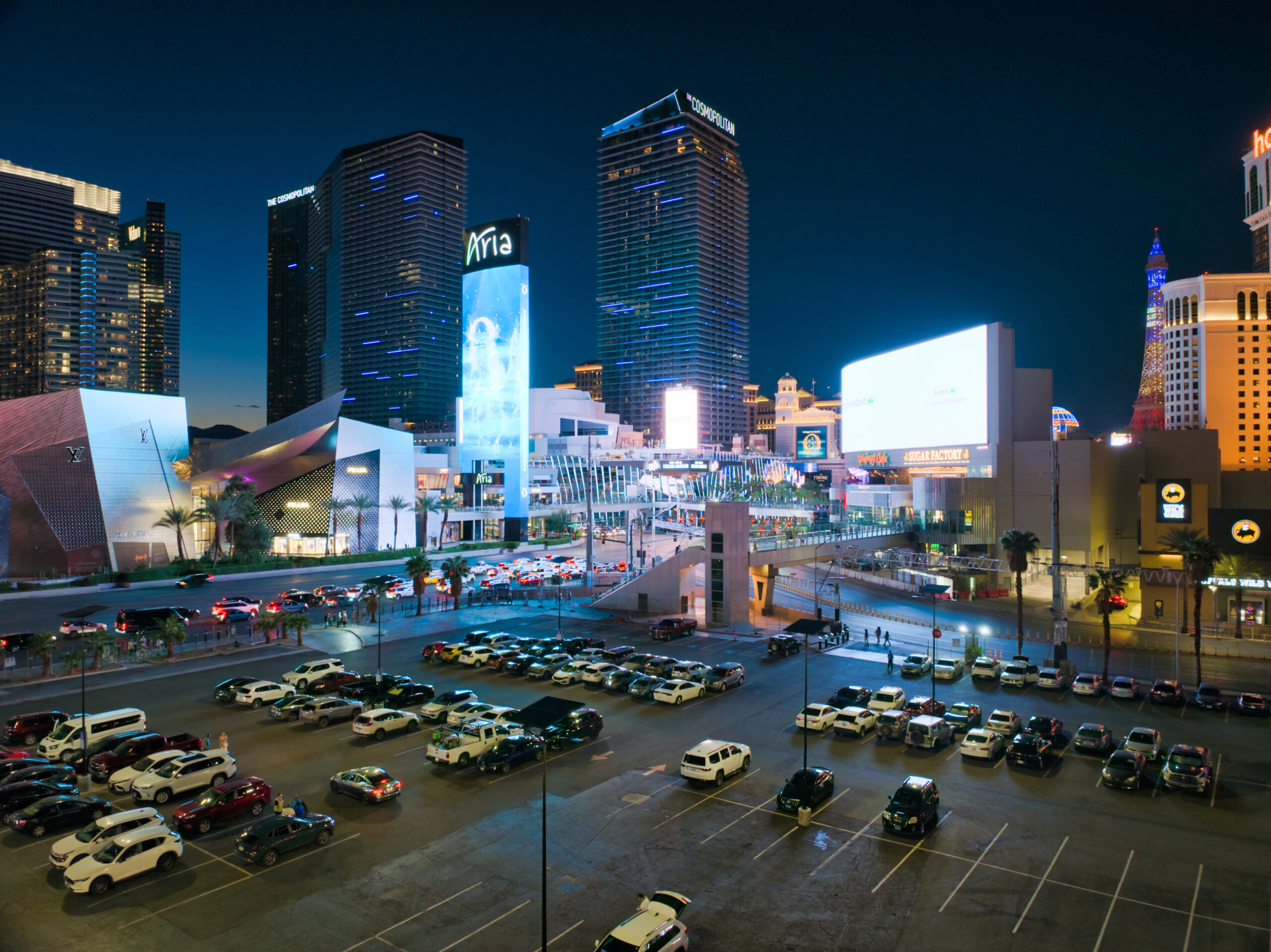 essential-solar-smartlights-parking-lot-aging-infrastructure Solar lighting illuminating an urban commercial parking lot at night