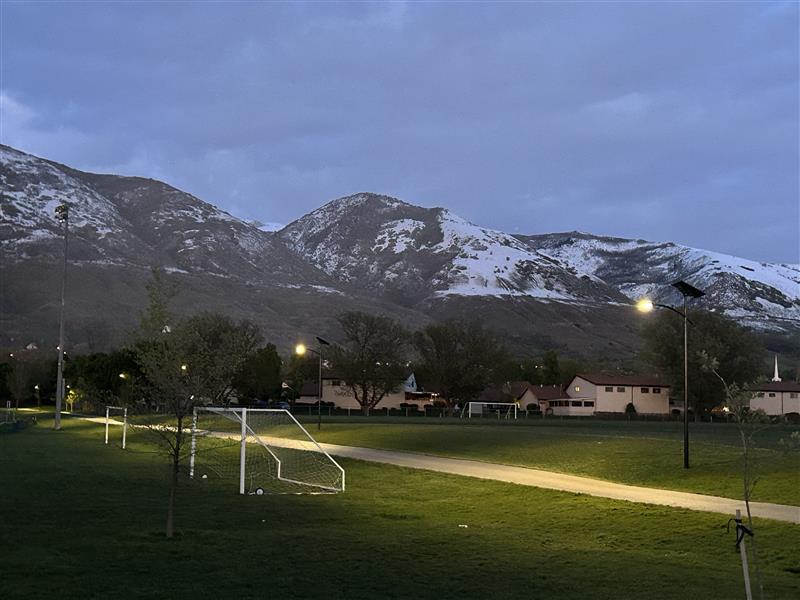 essential-solar-street-lights-pathway-trail Solar lighting illuminating a trailhead pathway and recreational parking area near mountains at dusk
