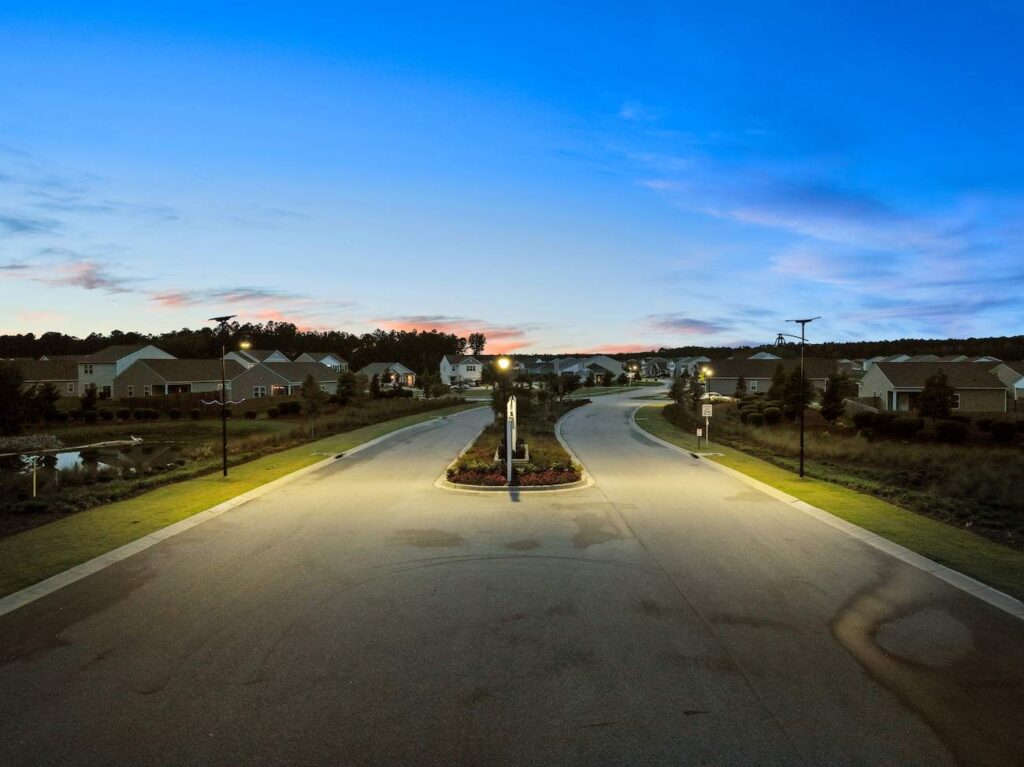 Solar streetlights illuminating a quiet Alabama residential neighborhood at dusk, showcasing grid-free lighting for modern municipal developments.