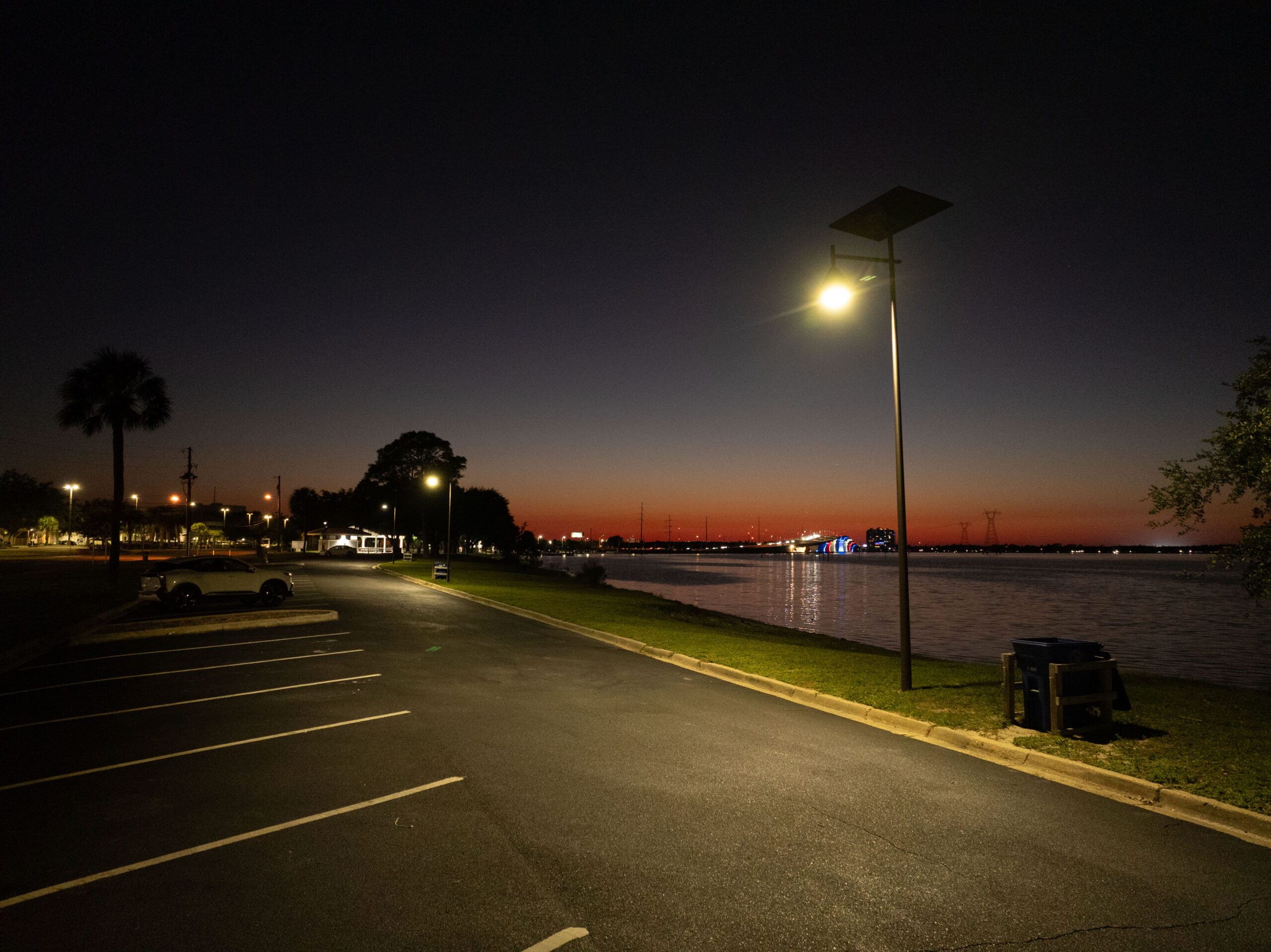 Fonroche solar lighting illuminating a parking lot along a body of water, enhancing safety and walkability without grid