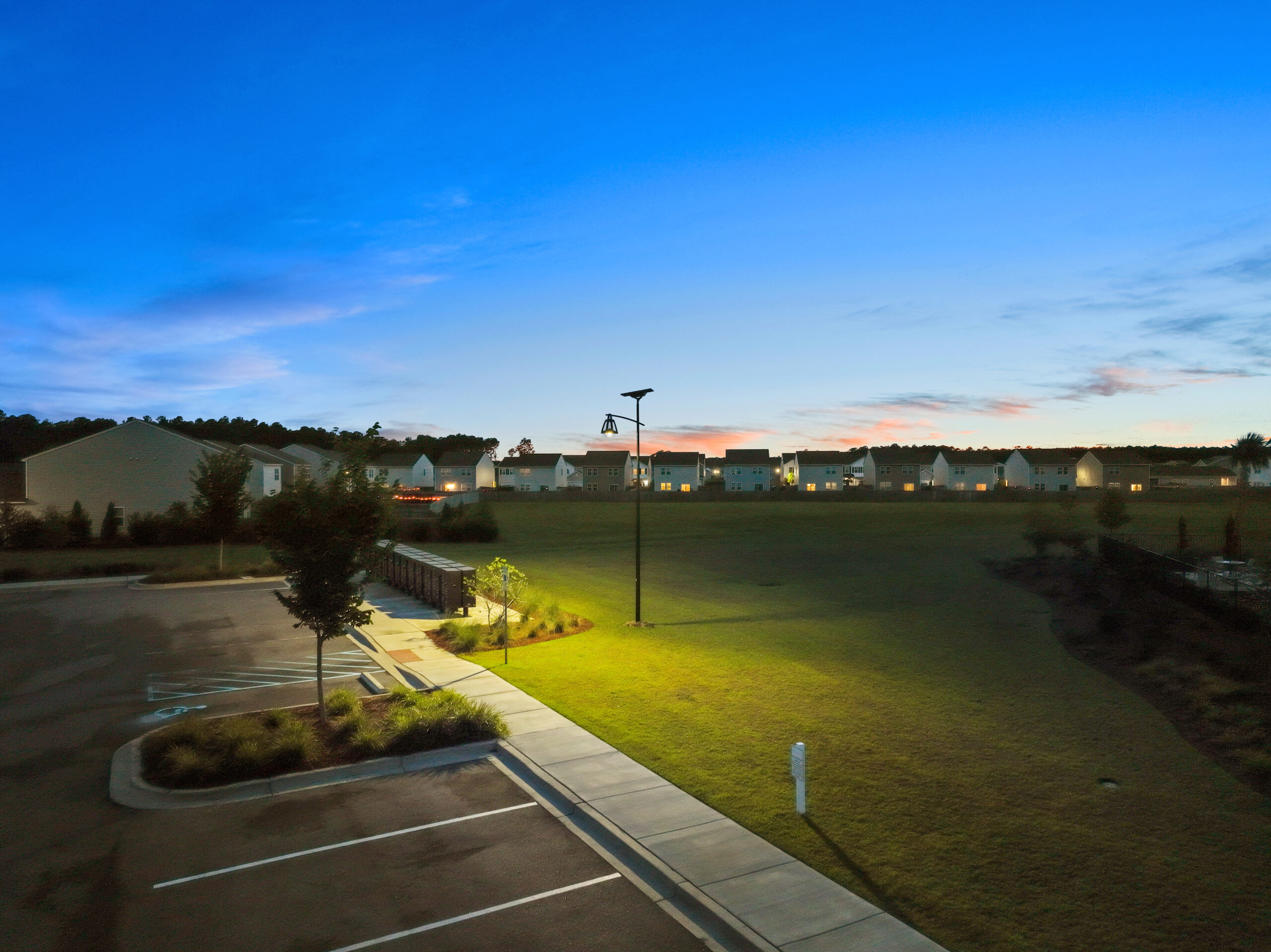 Fonroche solar lighting illuminating a residential parking lot at night with uniform, off-grid LED light for enhanced safety and visibility.