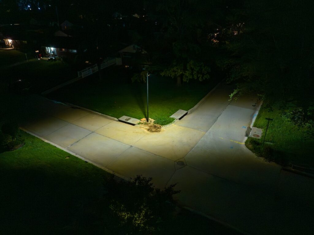 A solar streetlight illuminating a residential intersection at night in Alabama, enhancing neighborhood safety and visibility without grid power.