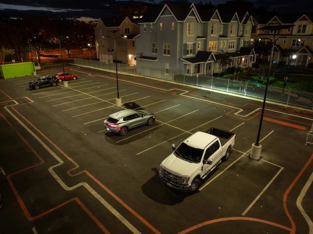 Solar-powered streetlights illuminating a residential community and parking lot at night, demonstrating reliable off-grid lighting suitable for HOAs and university campuses.