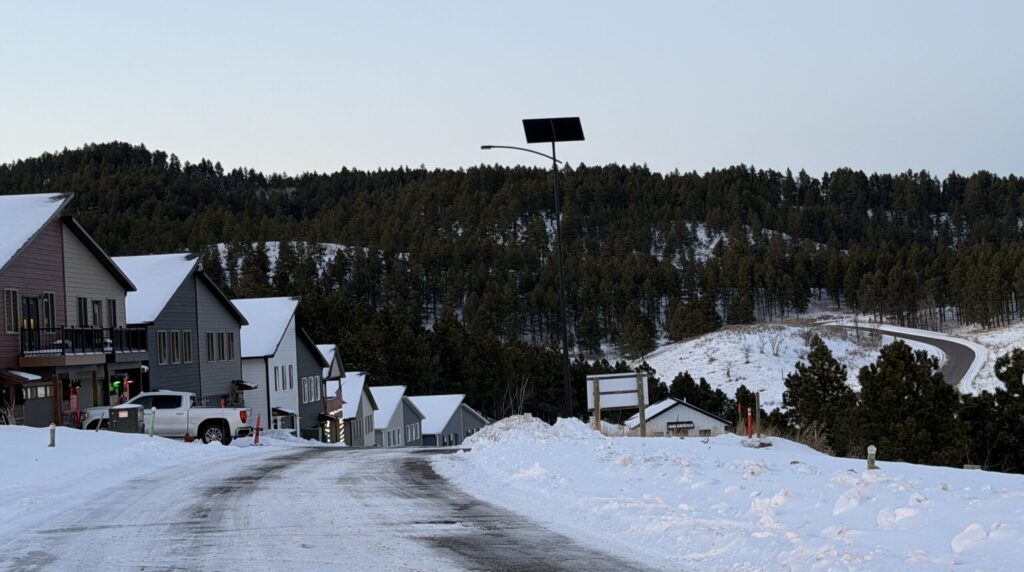 SmartLight solar street light illuminating a snow covered residential area during winter.