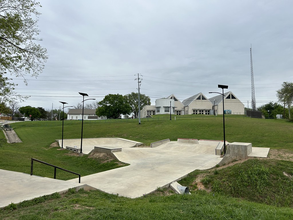 Public skatepark illuminated at night by solar-powered lighting, with skaters using ramps and bowls under even, off-grid solar smartlights.