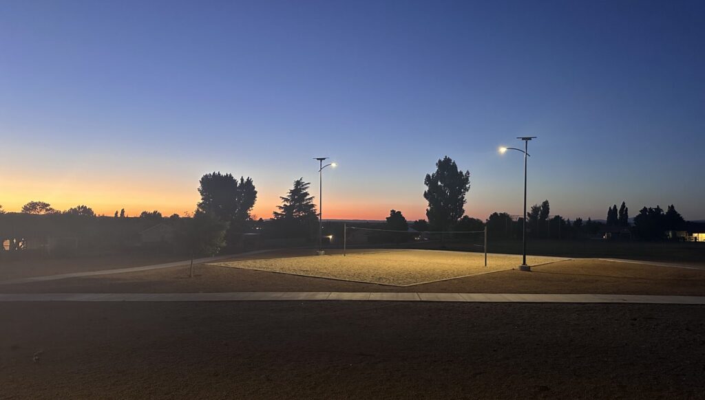 Solar-powered Fonroche Lighting illuminating a public park sports area at night, providing even, glare-free lighting for safe evening recreation.