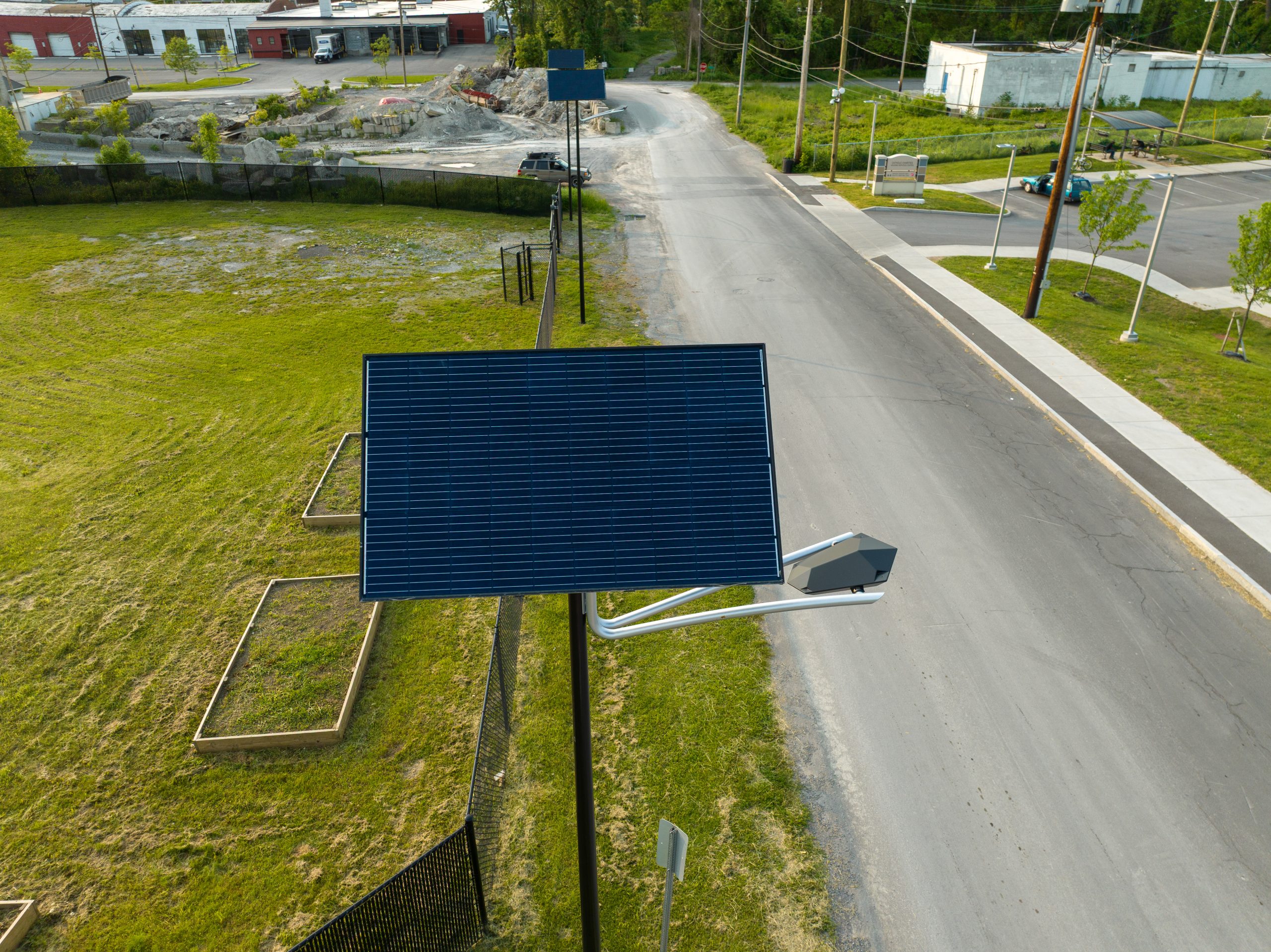 Close-up aerial view of NEW ART solar streetlight with integrated photovoltaic panel installed along a modern urban roadway.