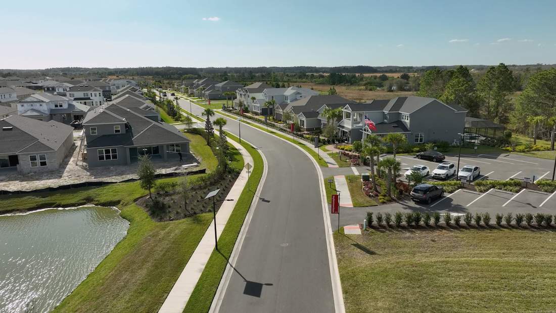 Solar-powered streetlight installed on a residential roadway with adjacent sidewalks and green space — no trenching, no grid connection required.