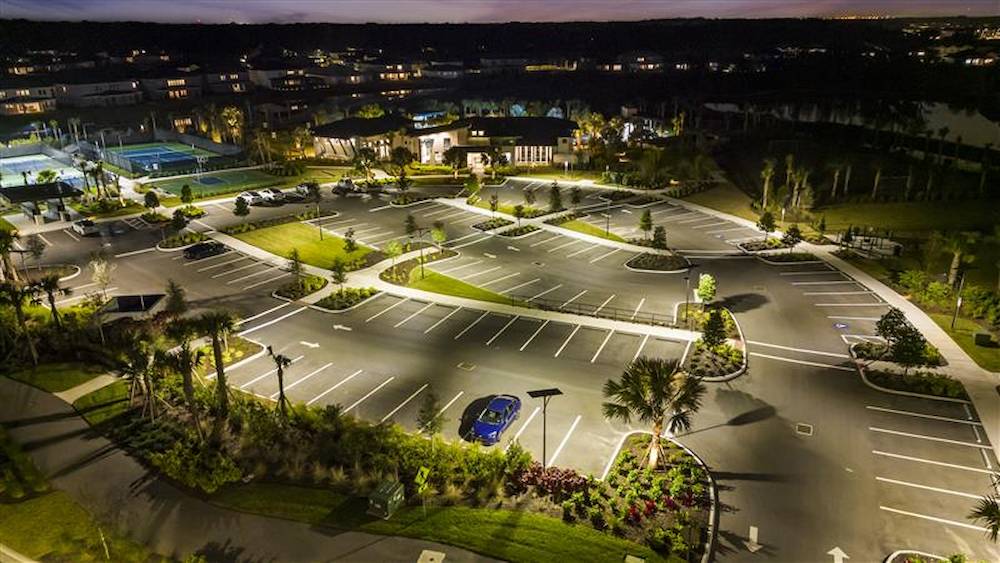 Solar street lighting illuminating a parking area in a Florida residential community development district at night
