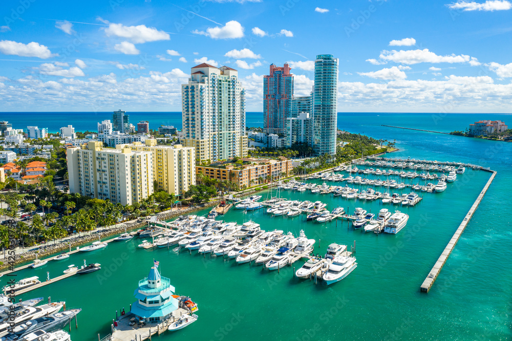 miami-beach-marina-skyline-florida-coastal-city-yachts Aerial waterfront view of Miami, Florida with high-rise developments and marinas representing solar lighting solutions for coastal communities.