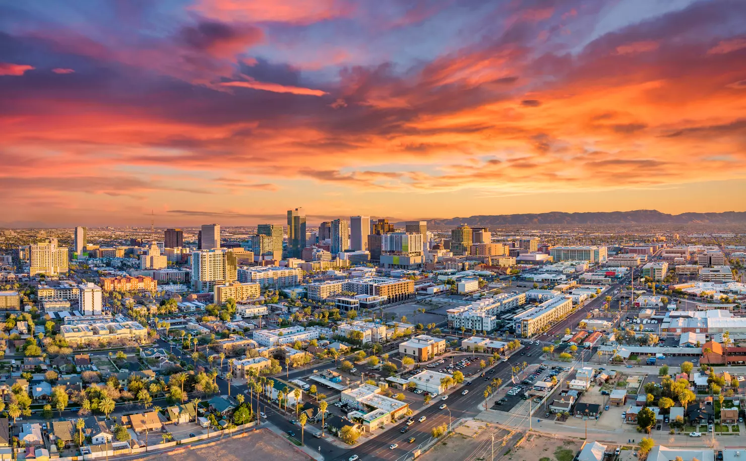 phoenix-arizona-skyline-desert-city-sunset-urban-infrastructure Aerial view of Phoenix, Arizona at sunset highlighting expanding infrastructure and roadway development supported by solar lighting solutions.
