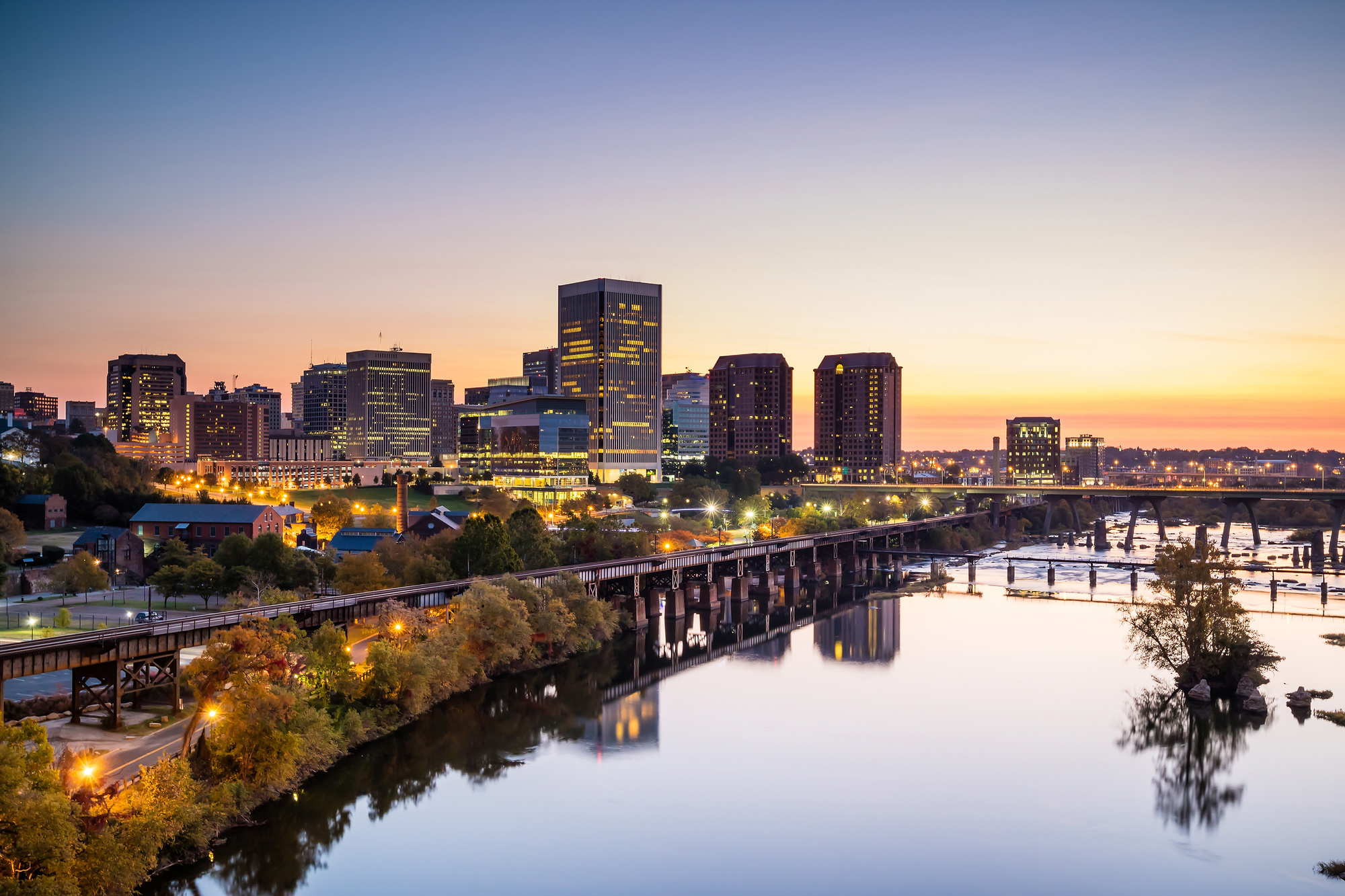 richmond-virginia-skyline-james-river-bridge-sunset-urban-lighting Evening skyline view of Richmond, Virginia along the James River representing modern infrastructure and solar lighting development projects.