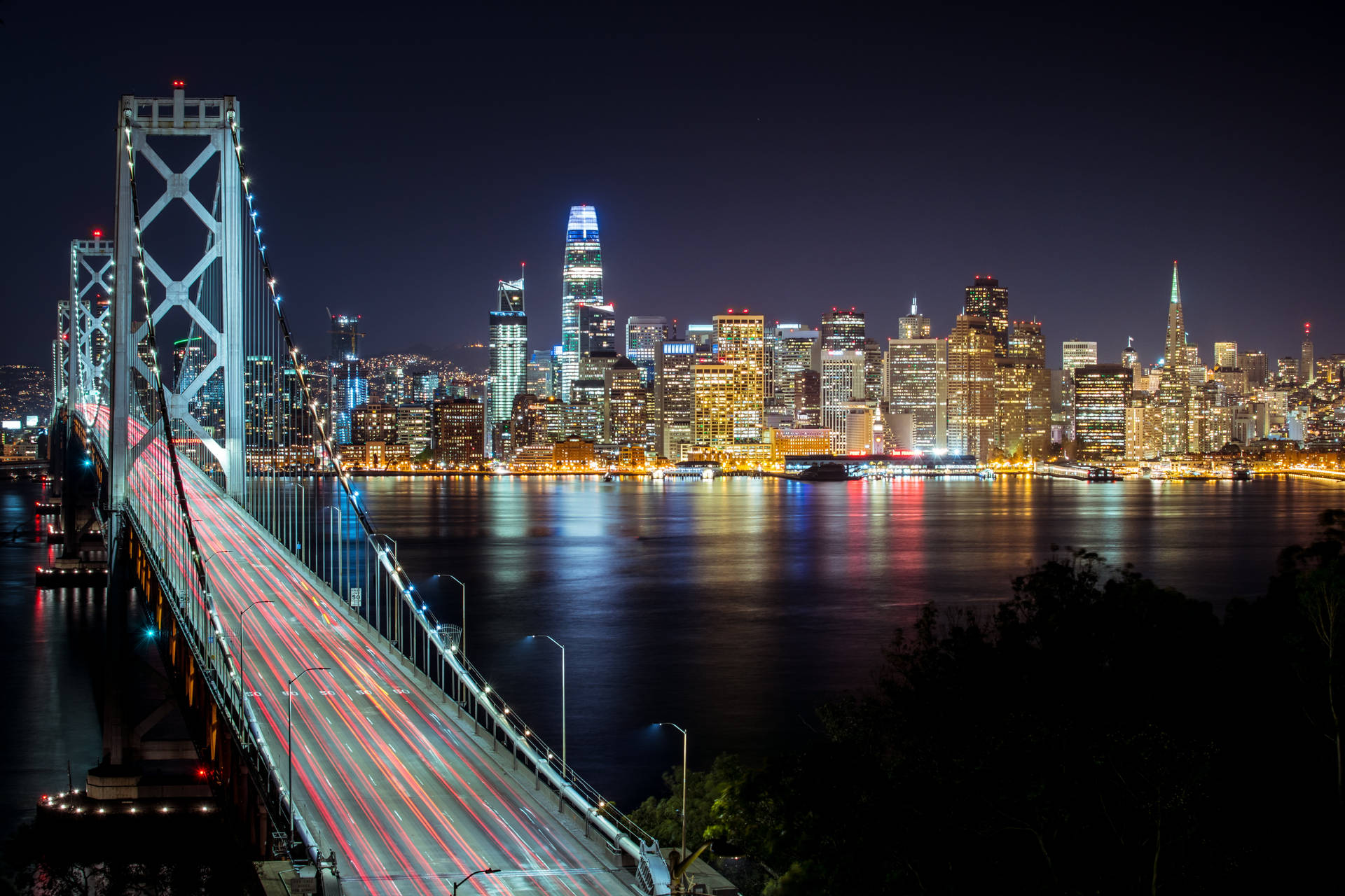 san-francisco-bay-bridge-skyline-night-california-urban-lighting Nighttime view of the San Francisco Bay Bridge and skyline representing sustainable urban infrastructure and solar lighting projects in California.