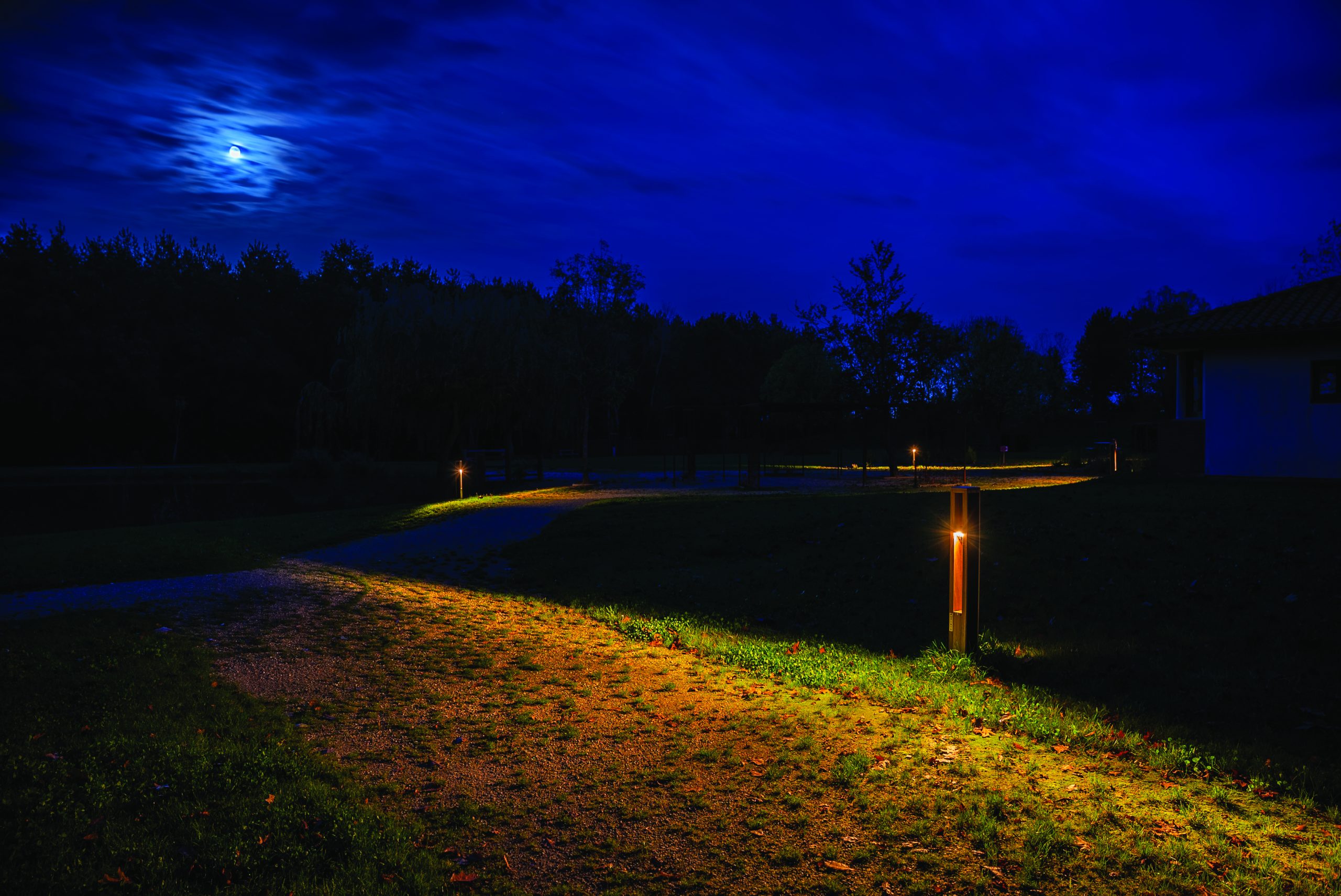 oko-solar-bollard-pathway OKO solar bollard lights providing nighttime pathway illumination in an open outdoor space with autonomous off-grid lighting.