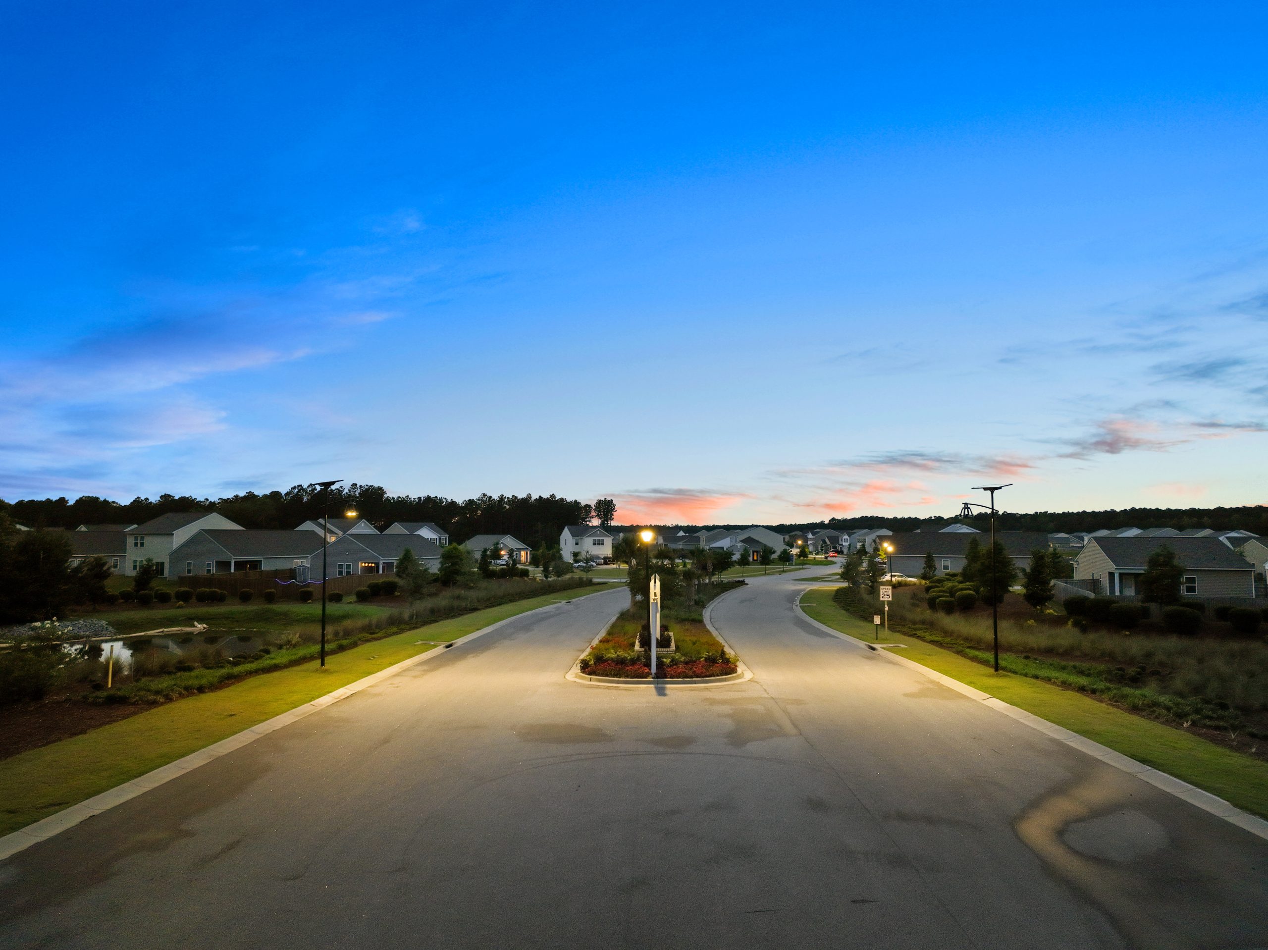 belle-epoque-solar-street-lights-residential A master-planned residential community illuminated with solar street lighting at dusk, showcasing sustainable outdoor lighting for neighborhood roads, sidewalks, and residential developments.