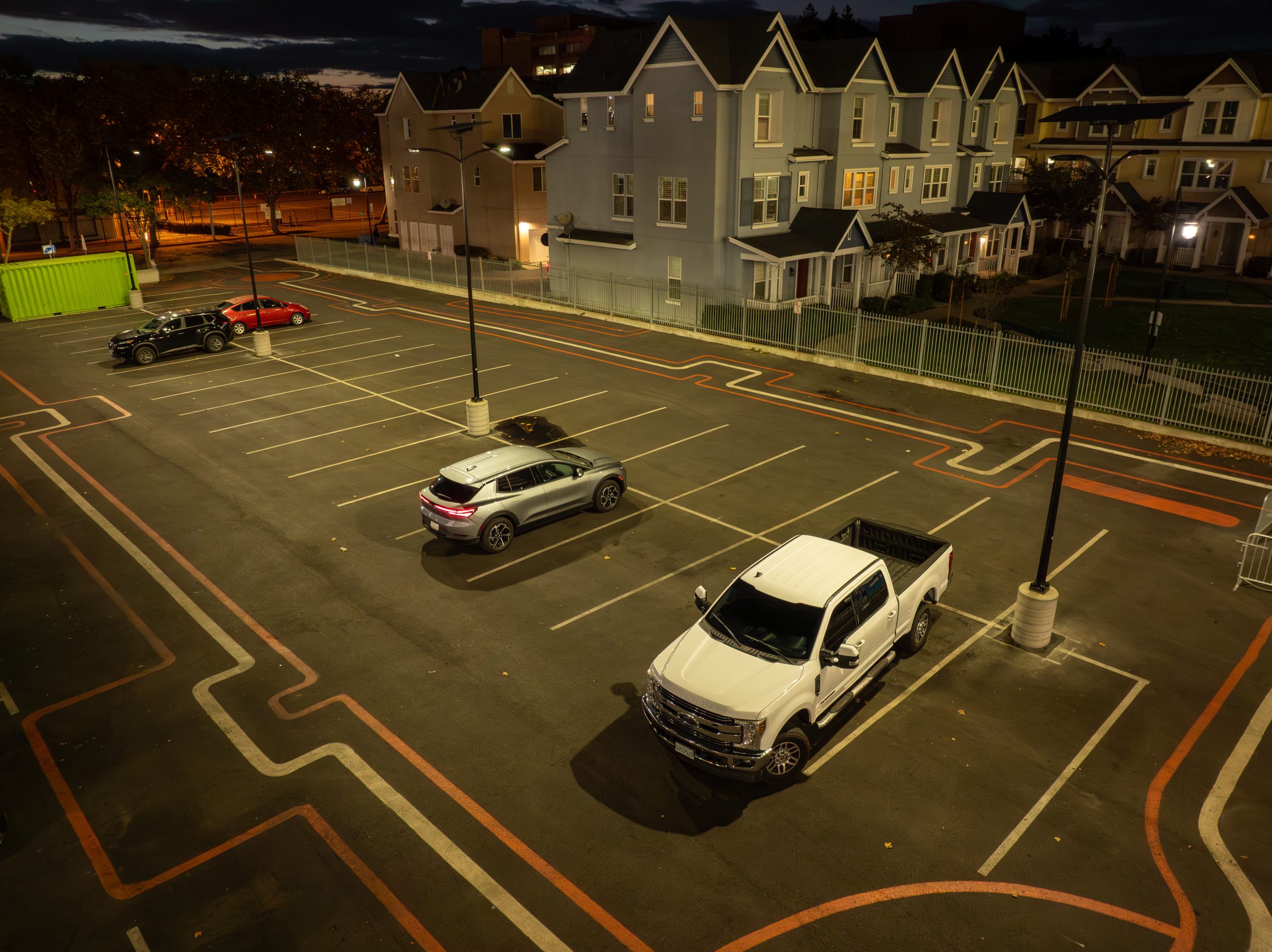solar-street-lighting-parking-lot-residential-area-essential ESSENTIAL solar street lights illuminating a commercial parking lot for safe nighttime visibility.
