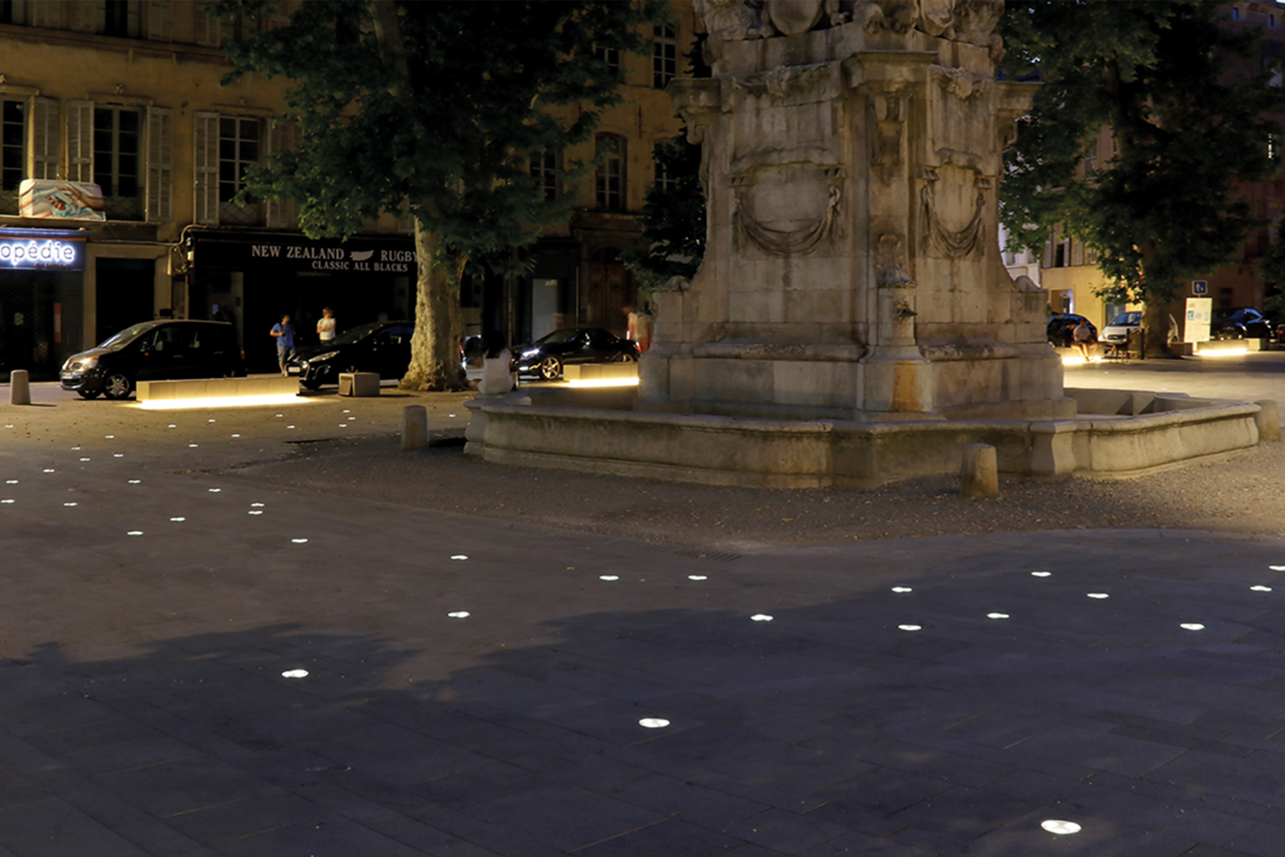 Nowatt in-ground solar lighting illuminating a public plaza and pedestrian gathering space at night.