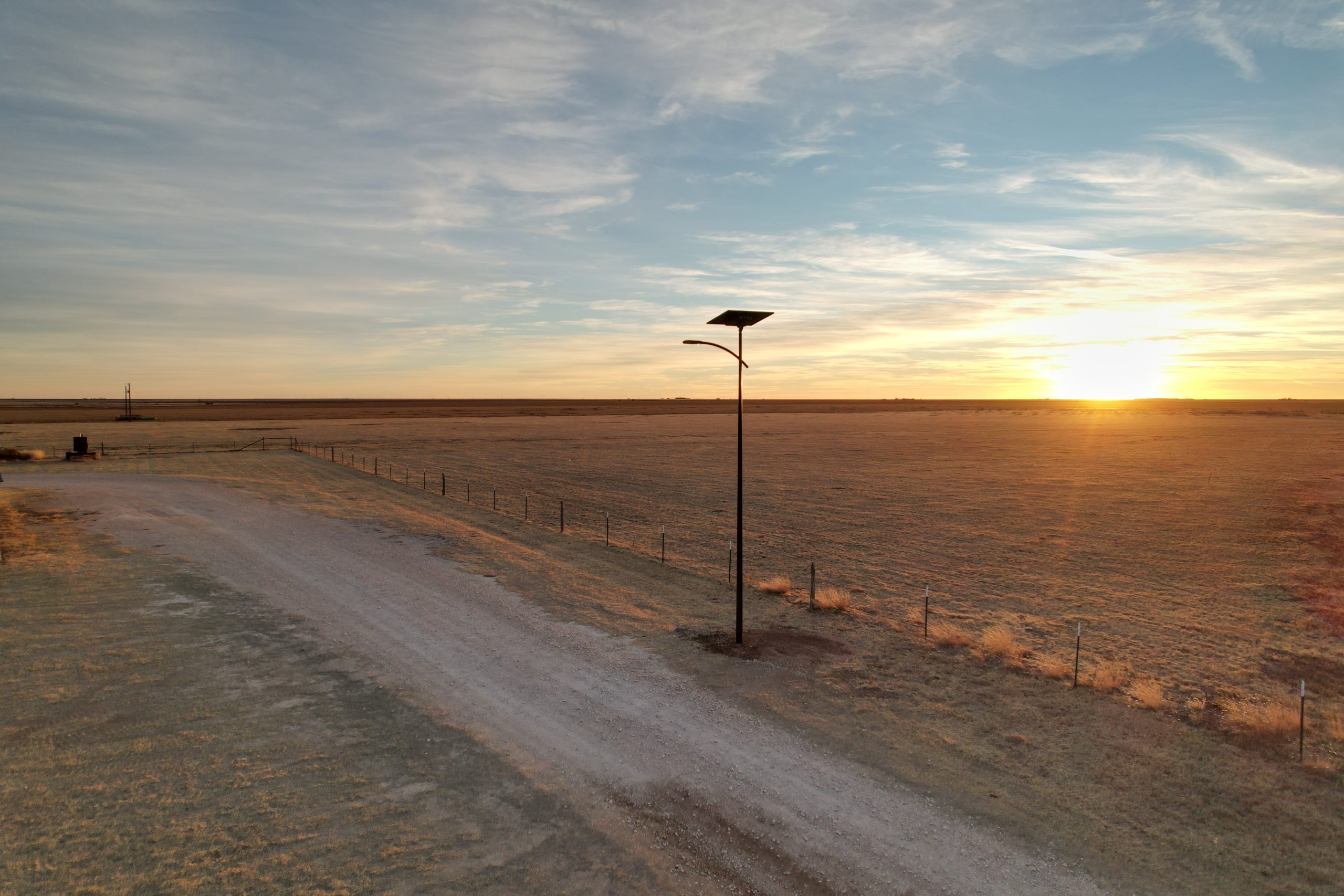 Solar-powered street light installed along a rural roadway in tribal land at sunset, providing resilient off-grid lighting for Native American communities.