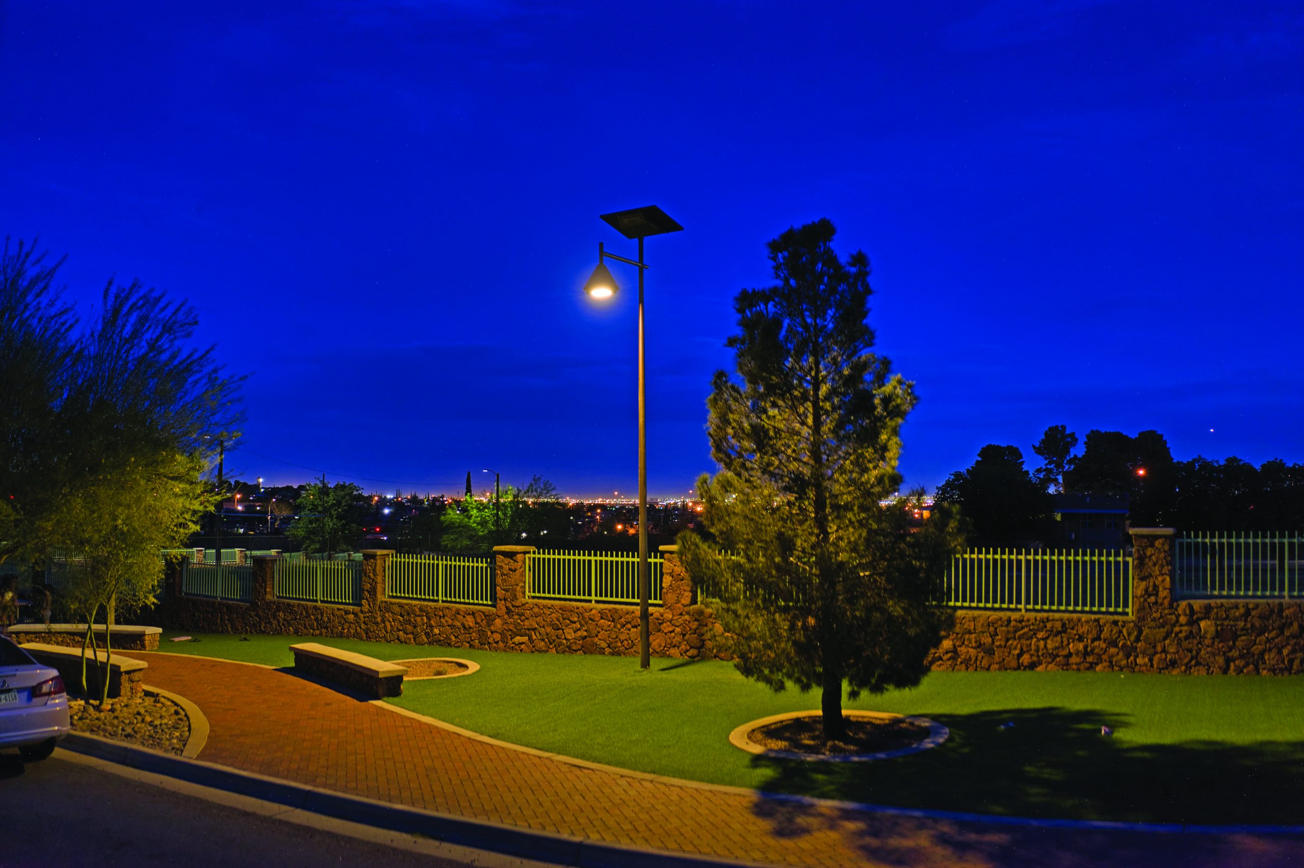 opera-decorative-solar-street-light-park-pathway-night.jpg OPERA decorative solar street light illuminating a landscaped pedestrian area at night with warm architectural lighting and off-grid solar performance.
