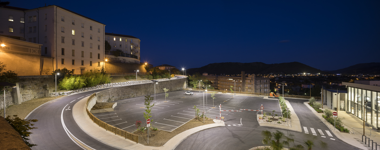 Solar-powered parking lot lighting illuminating a school campus parking and drop-off area at night with off-grid street lights for student and staff safety.