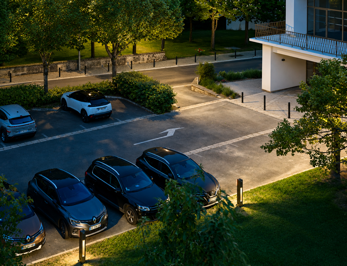 FOLLOW solar bollard lights illuminating a residential sidewalk and landscaped streetscape at night with modern, low-profile architectural lighting.