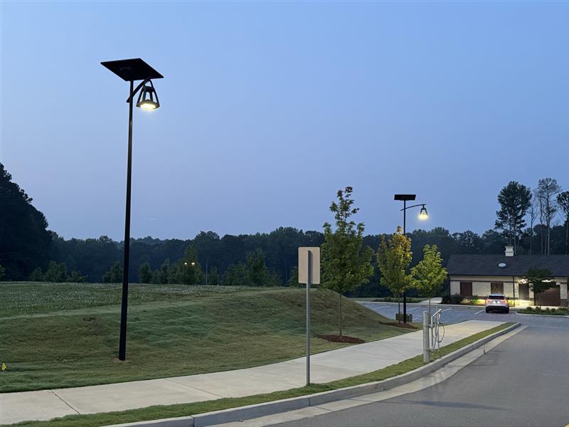 belle-epoque-solar-street-lights-parking-area Solar-powered parking lot lighting illuminating commercial guest parking and access areas at night with reliable off-grid LED street lights.