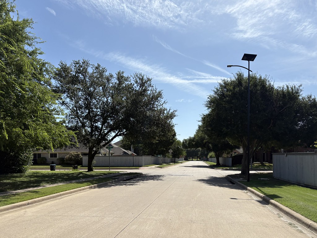essential-solar-street-lights-residential-neighborhood Solar street lighting installed in a master-planned residential community with off-grid light poles illuminating sidewalks, roads, and neighborhood entrances.