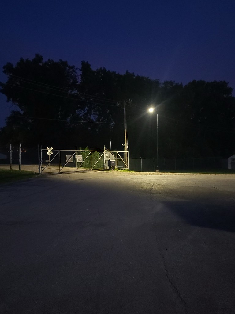 essential-solar-street-light-service-area Solar-powered street light illuminating an industrial loading dock and commercial service area at dusk with reliable off-grid lighting.