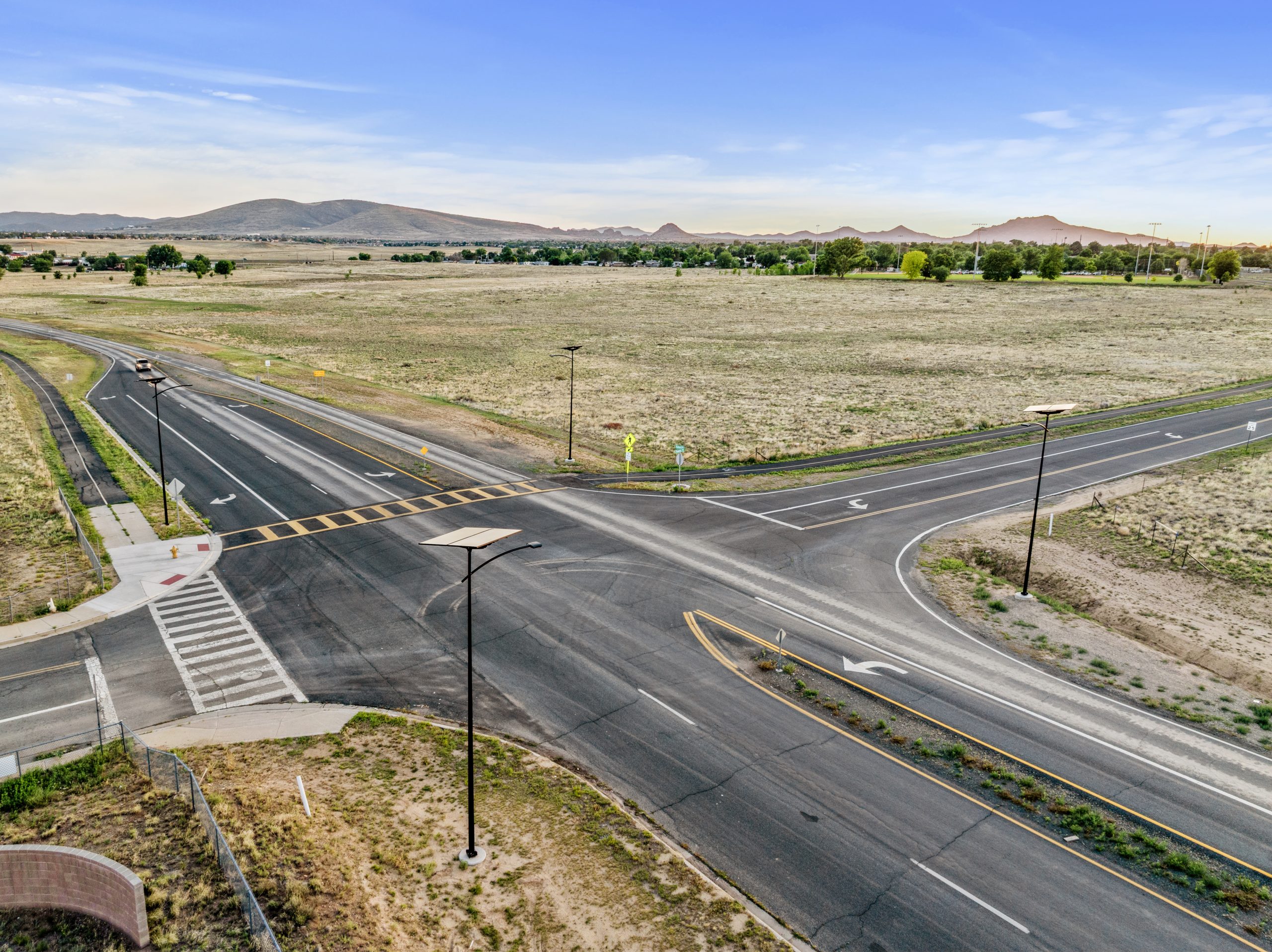 Solar-powered street lights illuminating a rural roadway intersection and pedestrian crossing in a tribal community with reliable off-grid lighting.