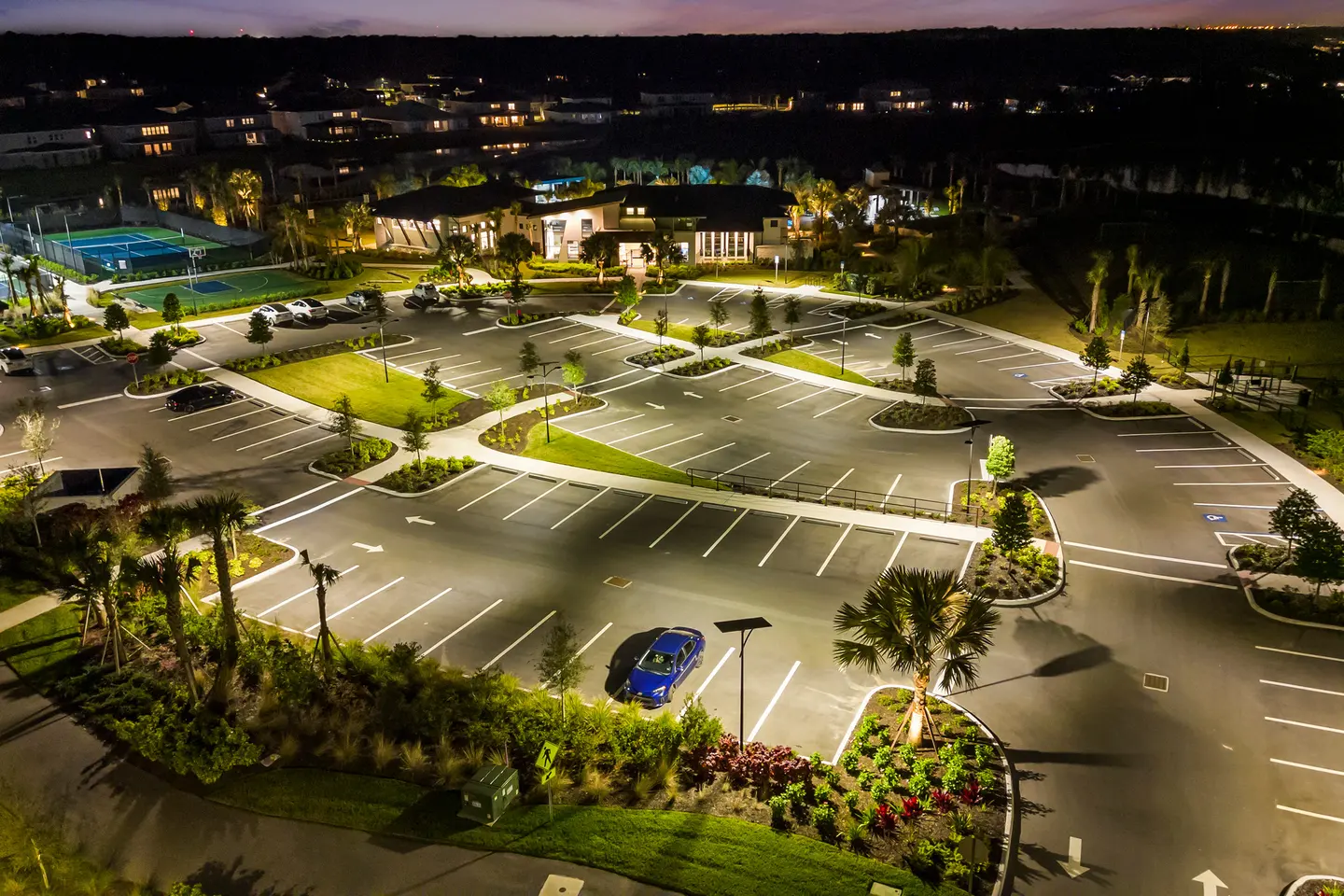 Solar-powered LED street lights illuminating a commercial parking lot at night, providing safe, uniform lighting without grid electricity.