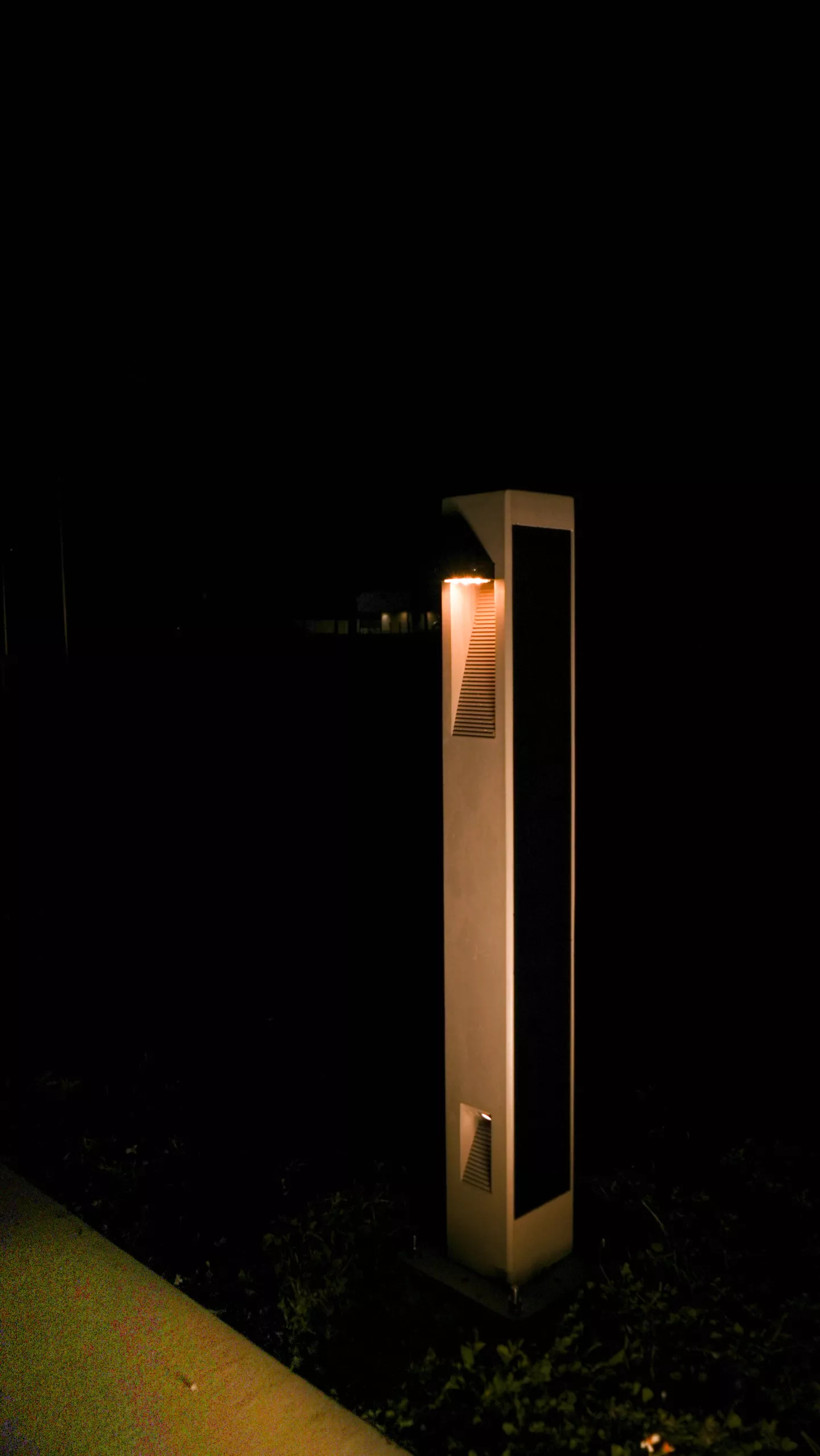 Close-up of a NOWATT BRUT solar bollard providing nighttime pathway illumination at Patriot Park Seawall in Madeira Beach, Florida.