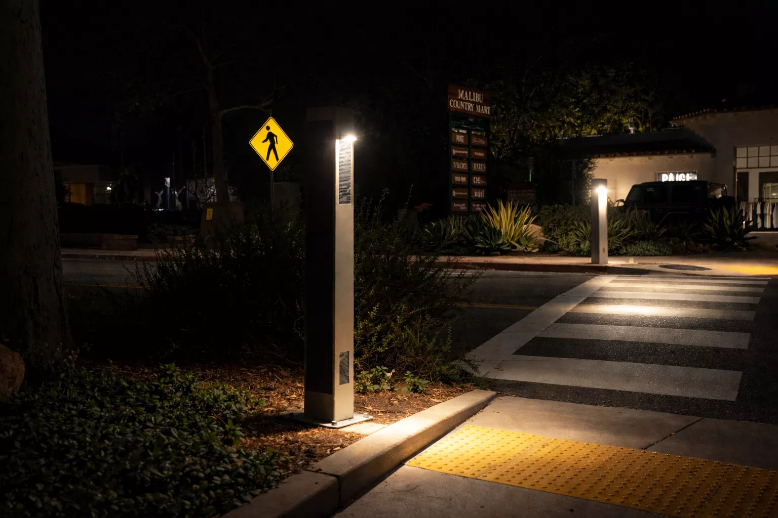 Solar bollards illuminating a pedestrian crosswalk to improve pathway visibility and safety in a public space.