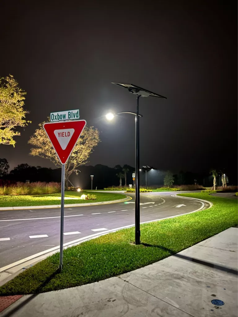 Off-grid solar streetlights illuminating a roadway intersection at night