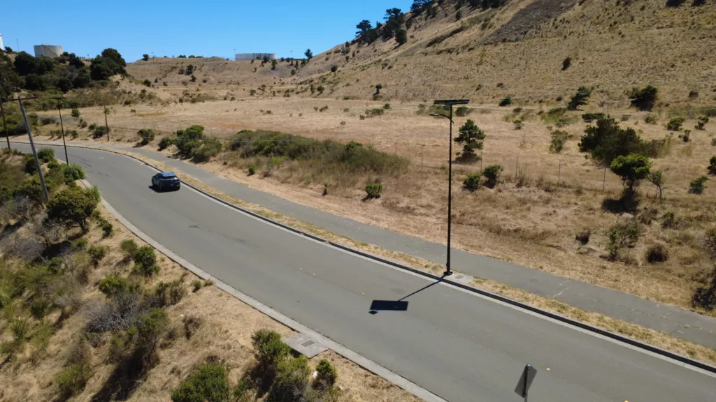 Solar streetlight installed along a roadway in a dry, open landscape