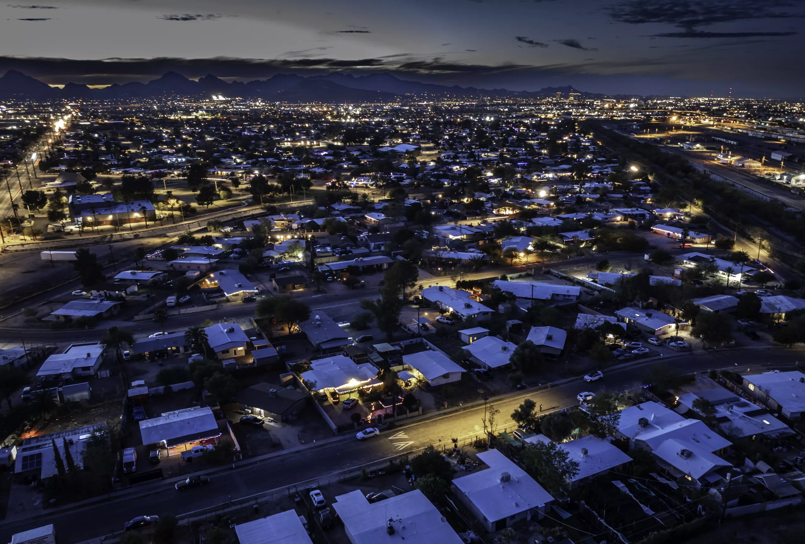 Nighttime view of street lighting across roads and residential neighborhoods