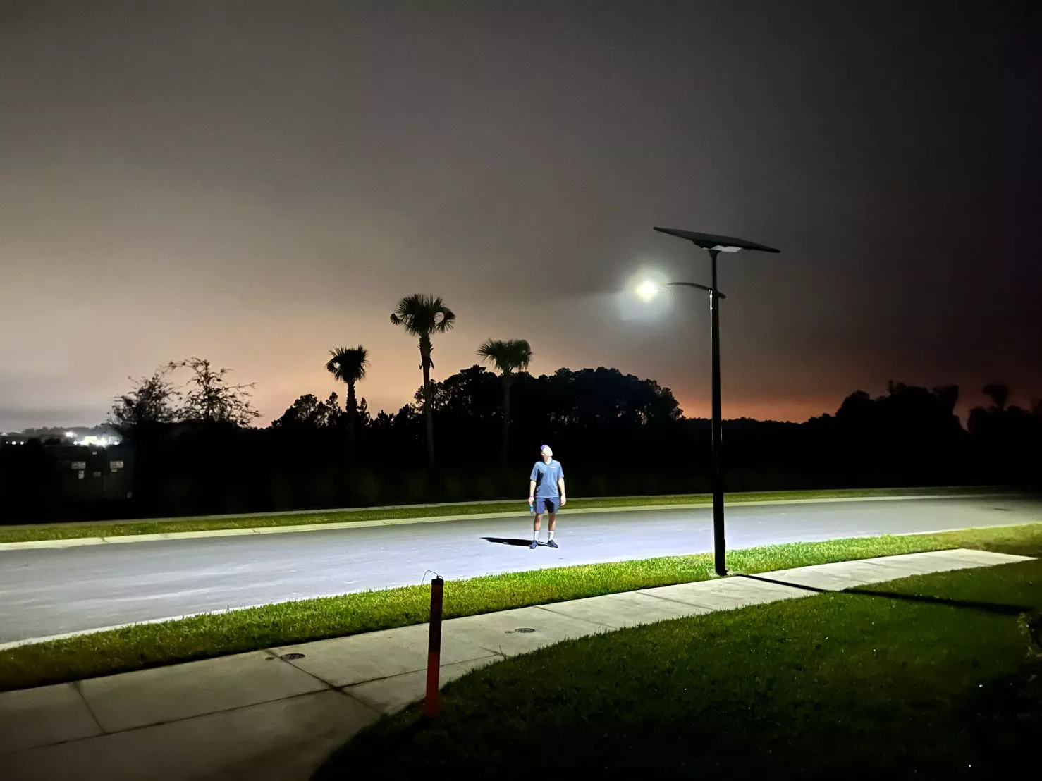 Off-grid solar streetlight illuminating a Florida roadway at night